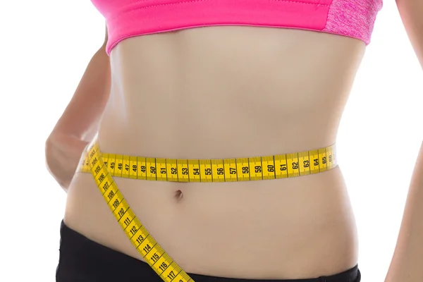 Fit woman measuring her waistline with a tape — Stock Photo, Image