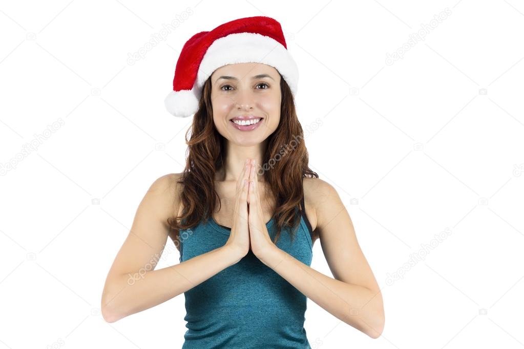 Yoga woman with santa claus hat in namaste pose