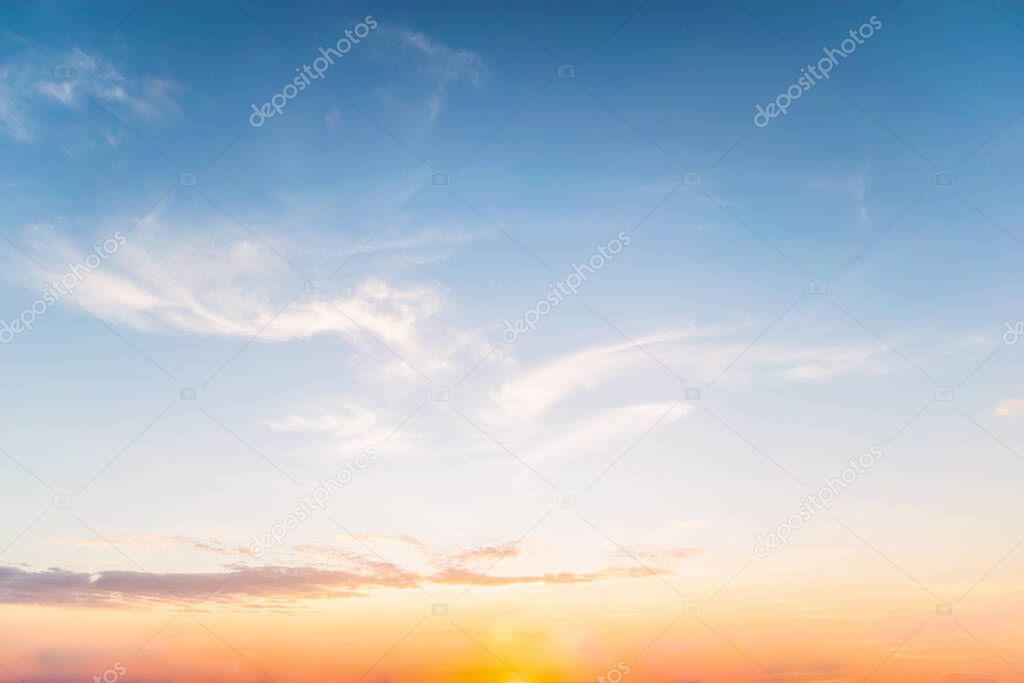 Sky blue and orange light of the sun through the clouds in the sky