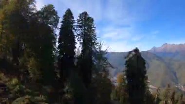 POV zaman çizelgesi sonbaharda dağlarda bir halatla yürür. Alplerdeki güzel altın ormanlar mavi gökyüzünün arka planında