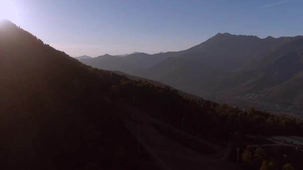 空中的景色掠过群山 向着一个五彩缤纷的日落飞去 秋天日落时山的全景 山区的旅行和娱乐 — 图库视频影像