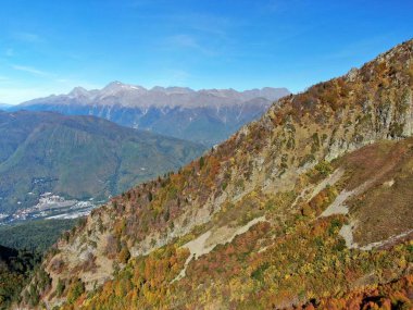 Mavi gökyüzünün arka planında gün batımında dağların panoramik manzarası. Dağlarda güzel gün batımı manzarası