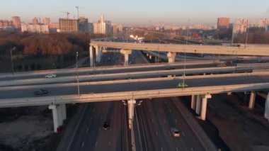 Gün doğumunda büyük şehrin merkezinde çok katlı ulaşım kavşağının hava manzarası. Modern şehrin güzel panoramik peyzaj altyapısı çok yükseklerden