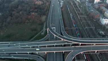 Gün doğumunda büyük şehrin merkezinde çok katlı ulaşım kavşağının hava manzarası. Modern şehrin güzel panoramik peyzaj altyapısı çok yükseklerden