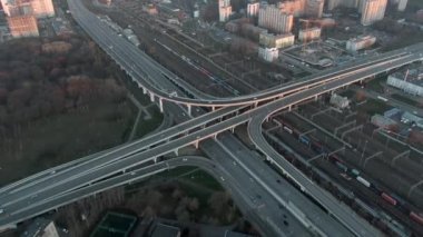 Gün doğumunda büyük şehrin merkezinde çok katlı ulaşım kavşağının hava manzarası. Modern şehrin güzel panoramik peyzaj altyapısı çok yükseklerden