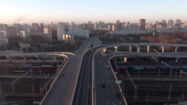 Gün doğumunda büyük şehrin merkezinde çok katlı ulaşım kavşağının hava manzarası. Modern şehrin güzel panoramik peyzaj altyapısı çok yükseklerden