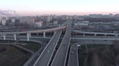Gün doğumunda büyük şehrin merkezinde çok katlı ulaşım kavşağının hava manzarası. Modern şehrin güzel panoramik peyzaj altyapısı çok yükseklerden