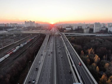 Gün doğumunda büyük şehrin merkezinde çok katlı ulaşım kavşağının hava manzarası. Modern şehrin güzel panoramik peyzaj altyapısı çok yükseklerden