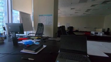 Ofiste, pencerenin dışında güzel bir manzarası olan bir yer. Camdan ve betondan yapılmış modern yüksek binalar..