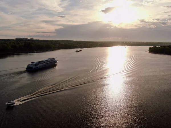 Aerial view passenger cruise ship sails along the river at sunset. Beautiful panorama of nature at sunset. Cruise trip