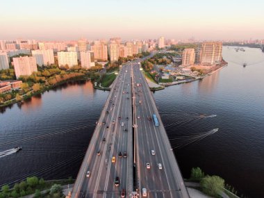 Hava manzarası gün batımında Moskova 'da köprüde güzel bir araba trafiği manzarasıdır. Gün batımında renkli şehir manzarası