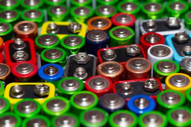 Bir sırada duran farklı markaların AA büyüklüğünde alkali pilleri kullanılmış. AA elektrik pilleri ve akümülatörlerinin üst görünüm arka plan dokusu. Adsız Alkolikler birbirine yakın paketlenmiş. Kullanılan AA piller