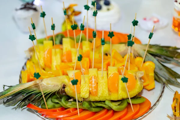 Ziyafet masasında orijinal meyve dilimleme. Meyve dilimlenmiş ananas, portakal, kivi, hurma, mandalina. Düğün büfesinde farklı taze meyveler. Büfe karşılama meyveleri.