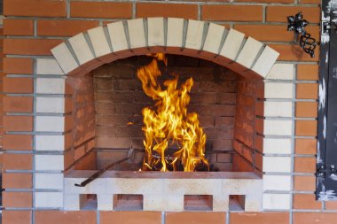 Ateş, barbekü, ızgara ve diğer açık hava yemekleri için bir yaz tuğlası fırınında yakılıyor. Pizza fırını ve ızgara ızgarası olan açık hava yaz mutfağı. Açık havada Brick BBQ Izgarası ve Fırın.
