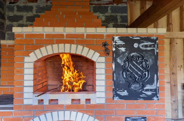 Ateş, barbekü, ızgara ve diğer açık hava yemekleri için bir yaz tuğlası fırınında yakılıyor. Pizza fırını ve ızgara ızgarası olan açık hava yaz mutfağı. Açık havada Brick BBQ Izgarası ve Fırın.