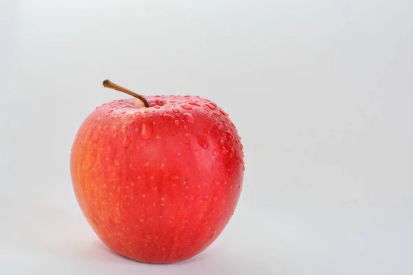 Pomme rouge et jaune avec des gouttelettes d'eau sur un fond clair — Photo