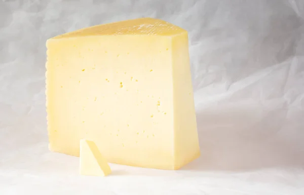 Ein Stück Käse Und Ein Kleines Stück Butter Auf Pergament — Stockfoto