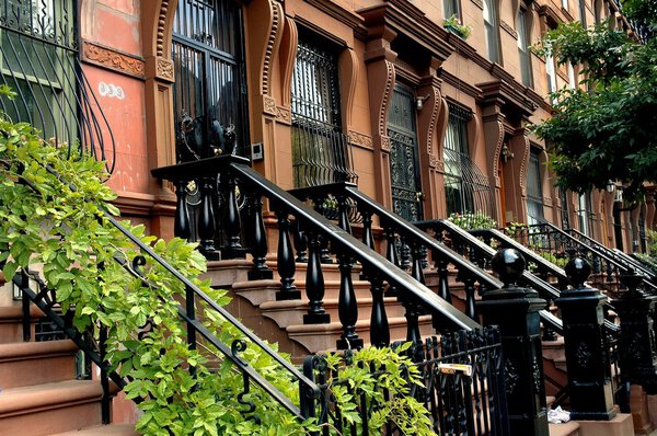 New York City - June 28, 2006: Handsome early 20th century brownstones with stoops and balustrades on West 121st Street in Harlem