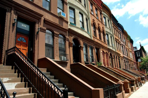 New York City - June 28, 2006: A row of finely preserved early 20th century brownstones with their original stoops on West 117th Street in Harlem