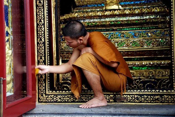 Бангкок, Таиланд: монах чистит стеклянную панель — стоковое фото