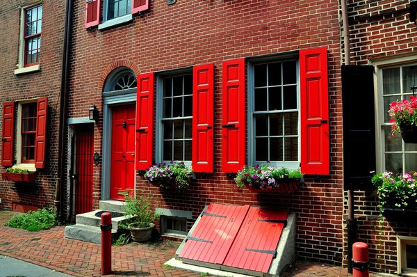 Philadelphia, Pennsylvania - June 25, 2013: 18th century olonial brick home with red fan doorway dating from 1703-1736 on historic Elfreth's Alley