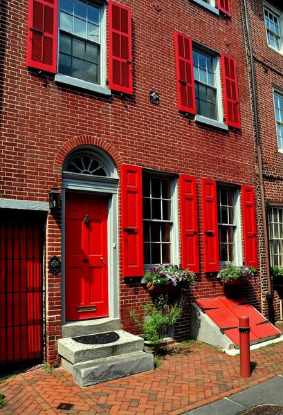 Philadelphia, Pennsylvania - June 25, 2013: 18th century colonial brick home with red fan doorway dating from 1703-1736 on historic Elfreth's Alley