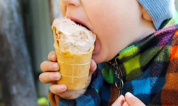 Close-up child lips eating ice cream cone. dirty face.