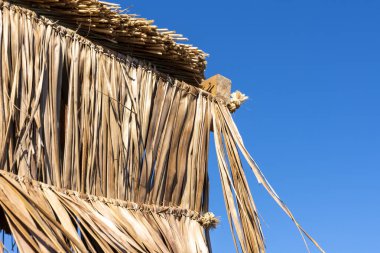 Atina 'daki Puta Zeza plajındaki plajda saman şemsiyeler