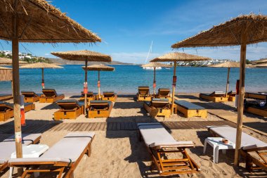 Atina 'daki Puta Zeza plajındaki plajda saman şemsiyeler