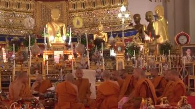 Bangkok - Tayland - Tayland 'da bir tapınakta rahipler sunağın önünde oturup vaaz okurlar