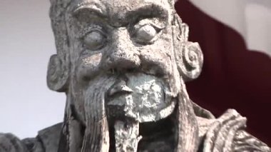 Bangkok 'taki Wat Arun Thai tapınağında asası olan bir adamın taş heykeli.  