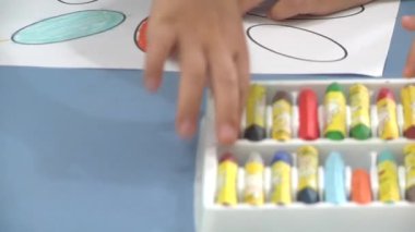 Anaokulundaki küçük bir çocuk kalemini çıkarıp çizmeye başlıyor. 