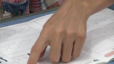 Anaokulunda ya da okulda bir öğretmen çocuğa geometrik şekiller gösterir ve görevi nasıl tamamlayacağını açıklar. 