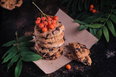 Çikolata ve Rowan 'lı kurabiyeler. Kurabiye kompozisyonu. Amerikan kurabiyeleri ve arka planda bir dal dağ külü..