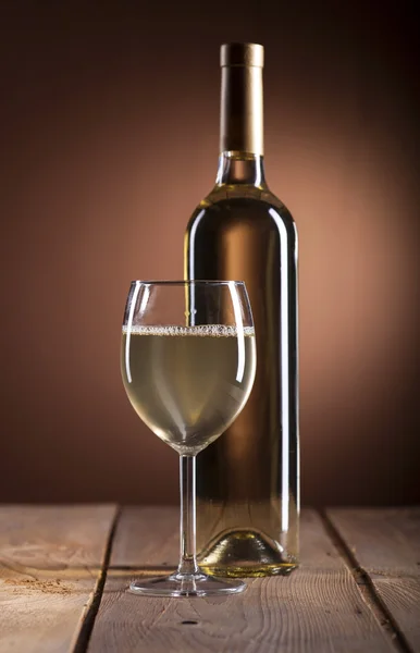 Винное стекло и бутылка белого вина — стоковое фото