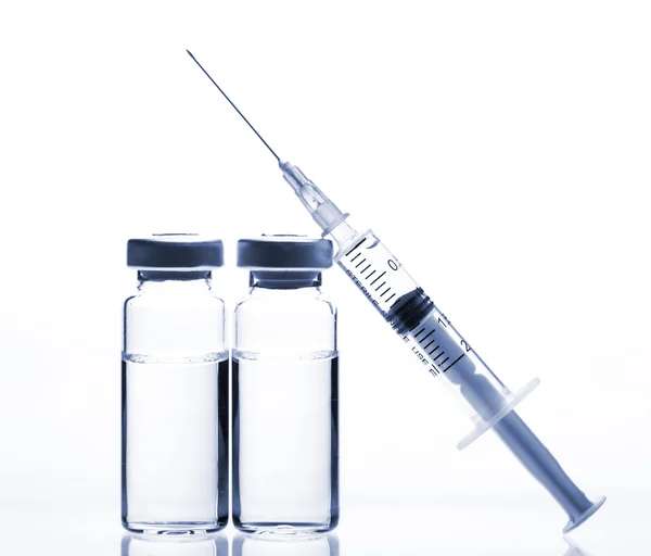 Frascos de medicamentos de vidro e seringa sobre fundo branco — Fotografia de Stock