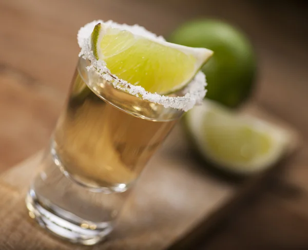 Colpo di tequila d'oro con frutti di lime — Foto Stock