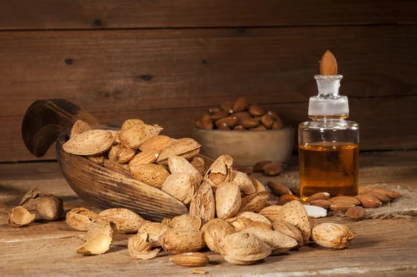 Almond oil on an old wooden background — Stock Photo, Image