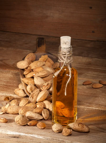 Almond oil on an old wooden background — Stock Photo, Image