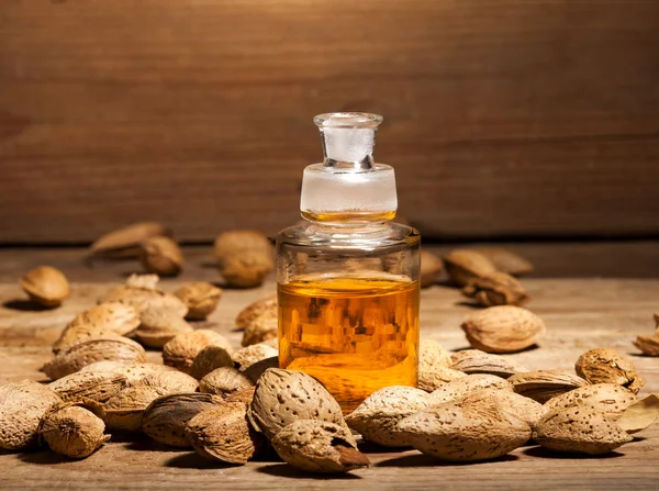 Almond oil on an old wooden background — Stock Photo, Image