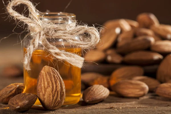 Almond oil on an old wooden background — Stock Photo, Image