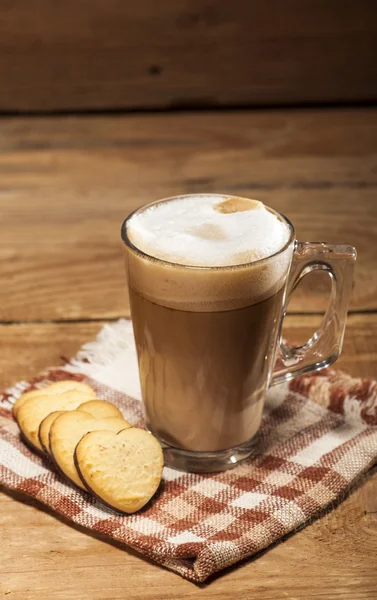 Glass cup with coffee and cookies in a heart shape — Stock Photo, Image