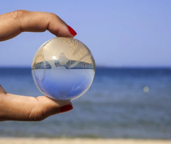 Mão humana segurando globo de cristal . — Fotografia de Stock