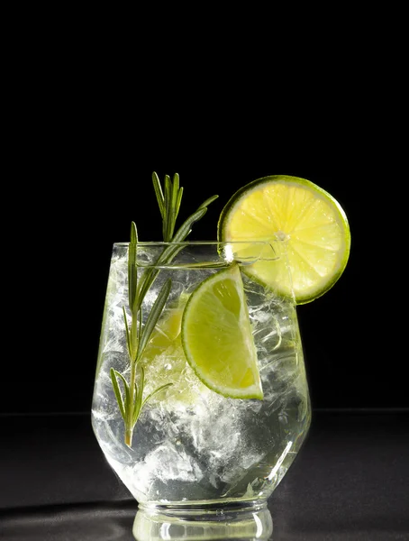 Gin and tonic cocktail con lime su sfondo nero . — Foto Stock