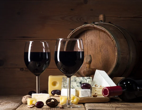 Vin rouge avec différents types de fromage sur fond en bois — Photo