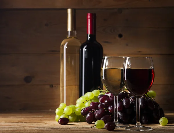 Vino tinto y blanco sobre fondo de madera — Foto de Stock