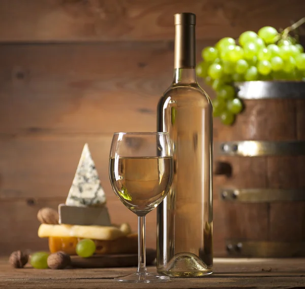 Vino blanco con varios tipos de queso sobre fondo de madera —  Fotos de Stock