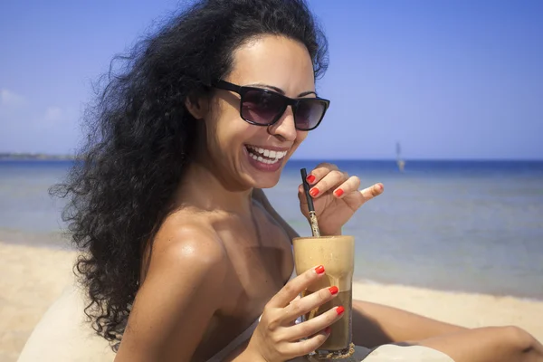 幸せな女の子飲むアイス コーヒー ビーチで ロイヤリティフリーのストック写真