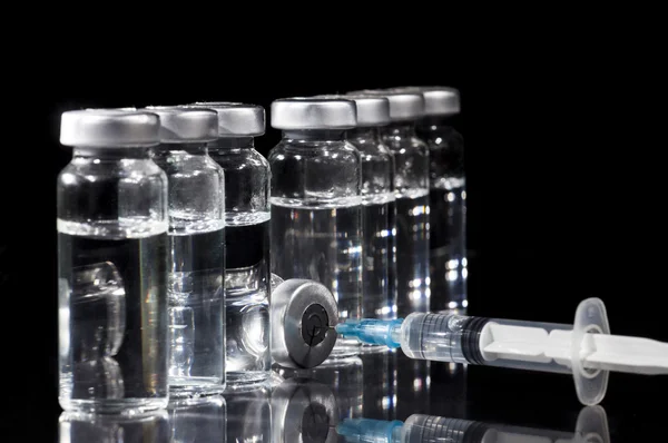 Скляні флакони медицини і шприц на чорному фоні — стокове фото