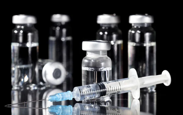 Glass Medicine Vials and Syringe on black background — Stock Photo, Image